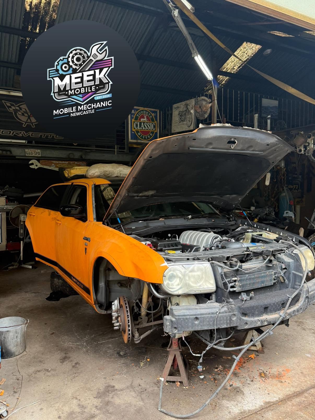 Orange Chrysler 300 SRT with bonnet up and front wheel off during a workshop service - Meek Mobile, Newcastle